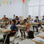 Siswa dan guru aktif dalam suasana kelas di lembaga pendidikan, mencerminkan semangat dan tantangan dunia pendidikan Indonesia saat ini.