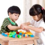 Anak-anak sedang bermain edukatif dengan balok warna-warni, menstimulasi kreativitas dan perkembangan motorik.