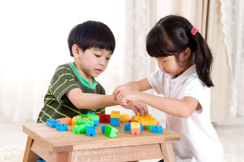 Anak-anak sedang bermain edukatif dengan balok warna-warni, menstimulasi kreativitas dan perkembangan motorik.