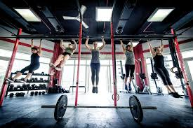 Pria sedang latihan angkat beban di gym modern dengan peralatan kekuatan penuh