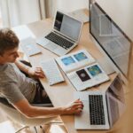 Pekerja remote menggunakan laptop di meja rumah, mencerminkan tren kerja remote 2025 yang fleksibel dengan peluang dan tantangan baru