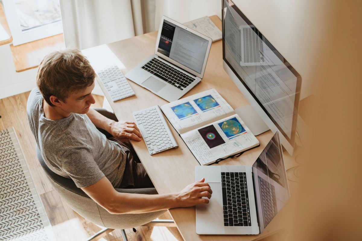 Pekerja remote menggunakan laptop di meja rumah, mencerminkan tren kerja remote 2025 yang fleksibel dengan peluang dan tantangan baru